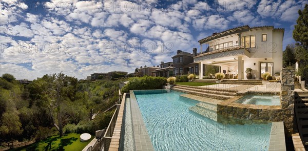 Swimming pool behind multiple story contemporary home