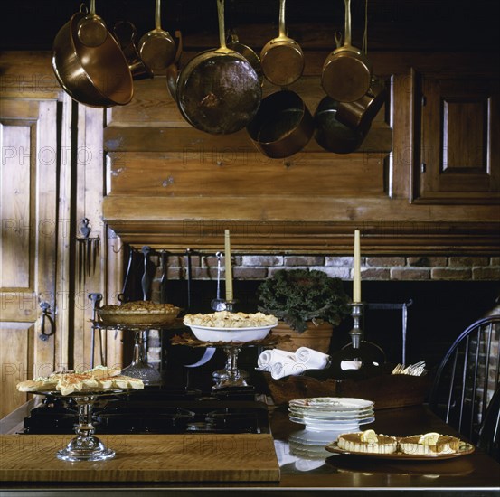 Cooking island set with desserts and antique hanging copper pots and utensils