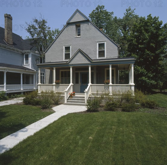 Facade of a gray stucco house with white and dark blue trim