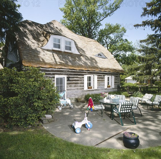 Rear exterior of log home with furniture in back patio