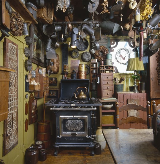 Old tin kitchen utensils and molds hanging from ceiling in country kitchen