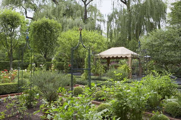 Shaped hedges surround flower beds in controlled rectangles with paths leading in between