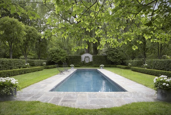 Formal shaped hedge garden with narrow pool