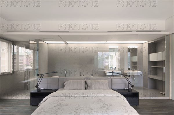 Modern bedroom with glass wall through to bathroom