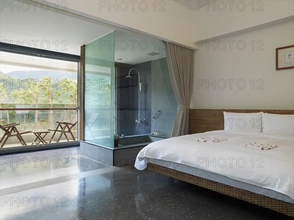 Modern bedroom with glass shower and outdoor patio