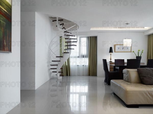 Living room and dining room with spiral staircase in corner