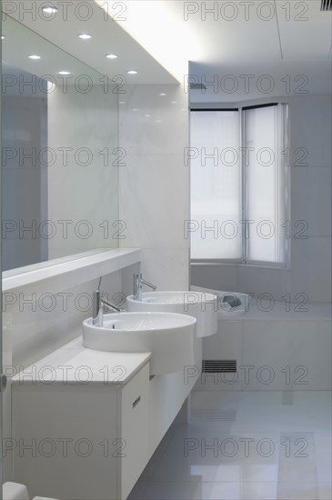 Double bowl sinks in white bathroom