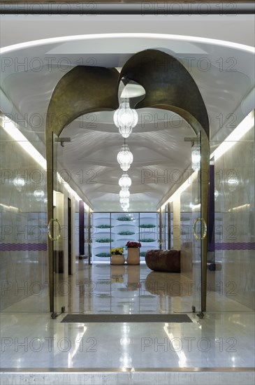 Long marble hallway with double glass doors at end
