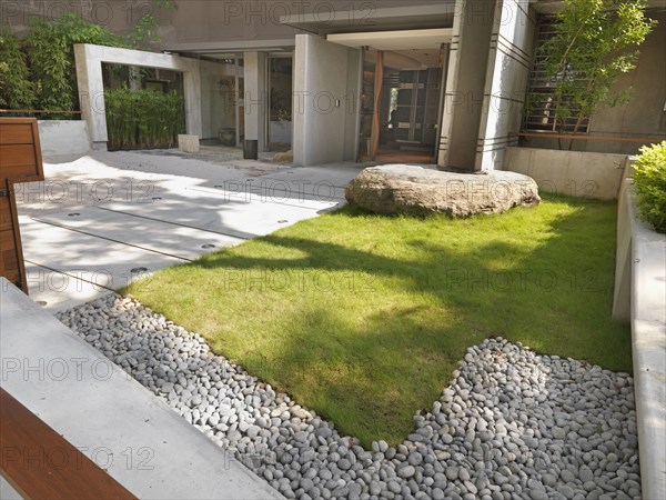 Grass and sidewalk outside front entrance of modern building