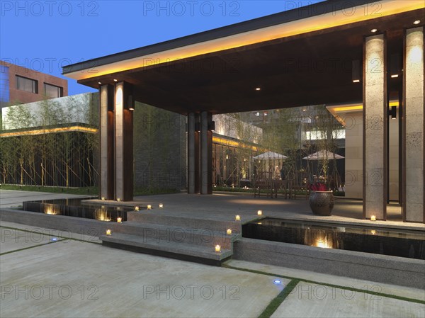 Covered stone patio with steps over infinity pool