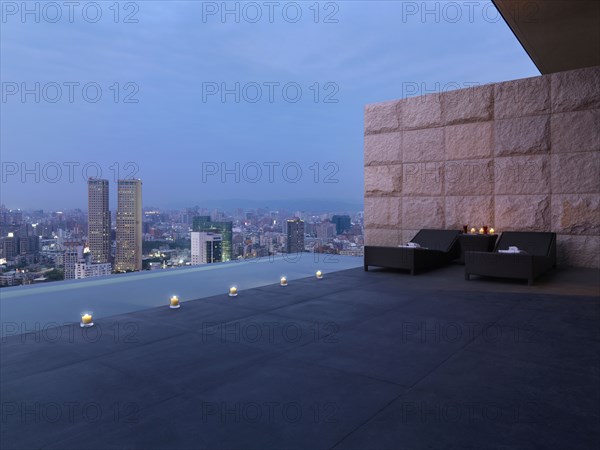 Two lounge chairs on outdoor terrace above city