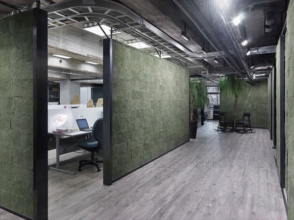 Modern circular table with tree in center in industrial office building