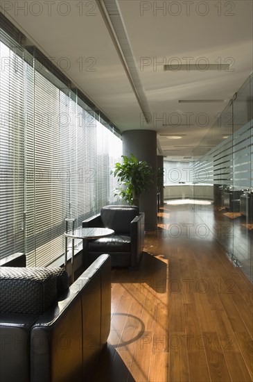 Black leather armchairs in hallway near windows