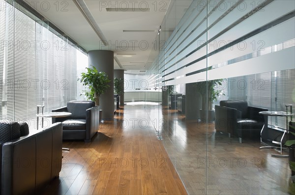 Black leather armchairs in hallway near windows