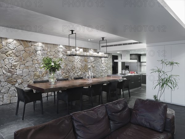 Modern great room with slate tile floor and a stone wall