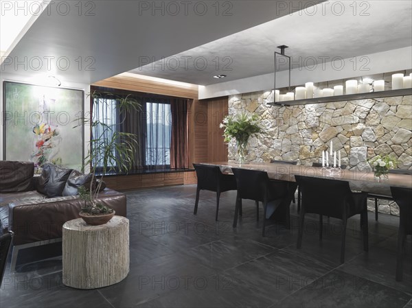 Modern great room with slate tile floor and a stone wall