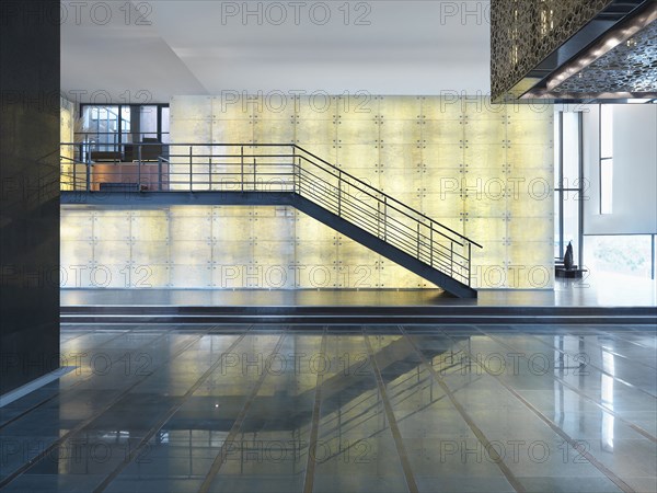 Open lobby with staircase in front of illuminated wall