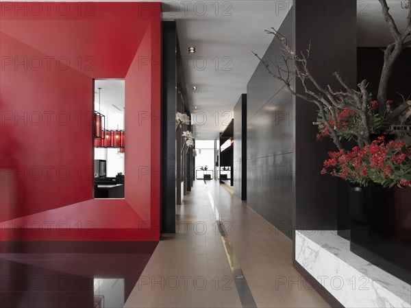 Hardwood hallway in modern building with red accent wall