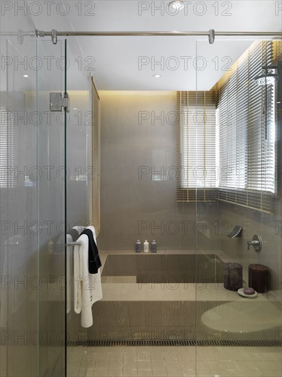 Large bathtub behind glass wall and door