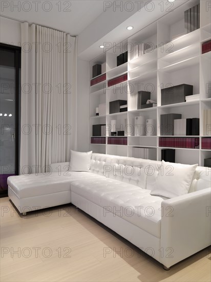 White sofa in front of wall bookcase