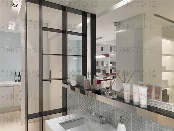 Beauty products on ledge above modern sink