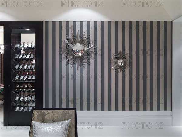 Striped wall with decorative mirrors and wine cooler