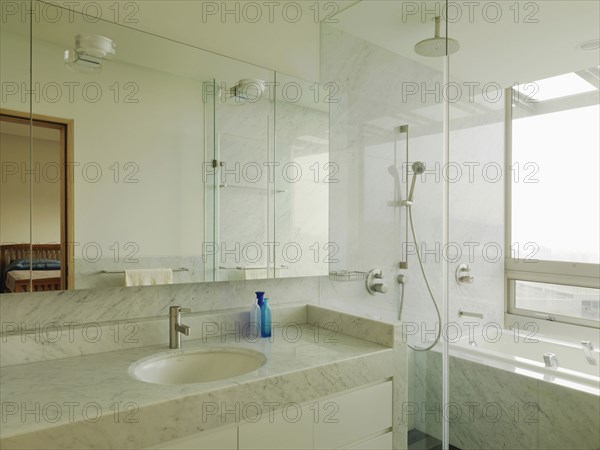 Clean modern bathroom with marble countertop and bathtub