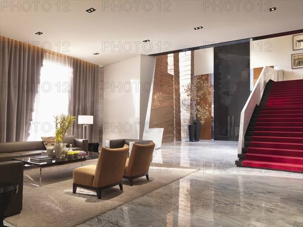 Sitting area and grand red staircase in modern interior