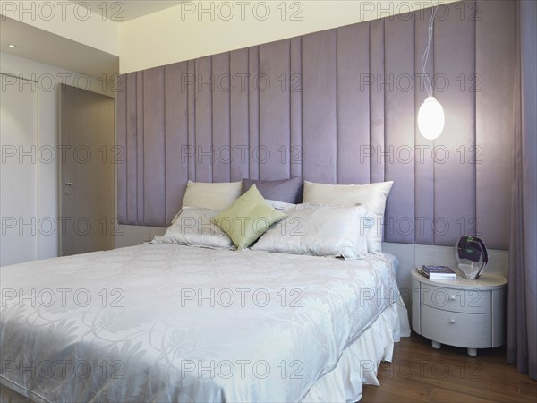 Bed with pillows and purple headboard