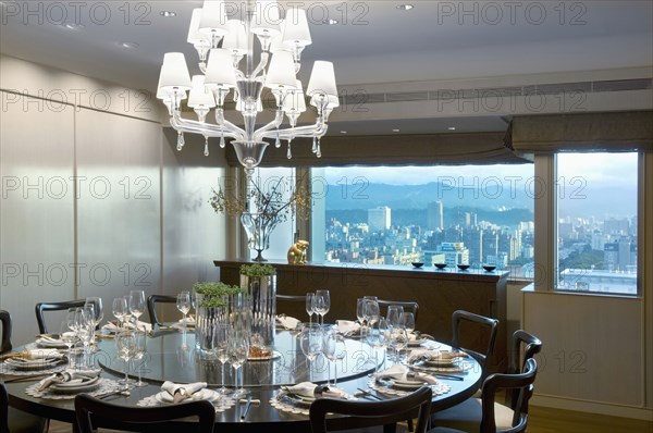 Large circular dining table in dining room with city view