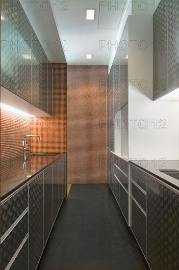 Modern kitchen with cabinets and mosaic tile wall