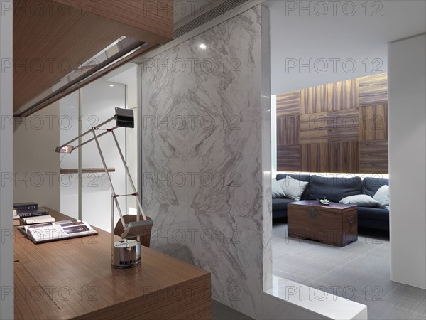 Marble wall dividing home office from living room