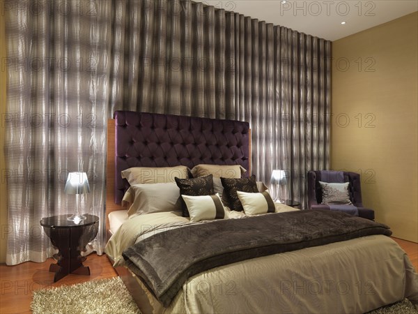 Elegant modern bedroom with purple velvet headboard