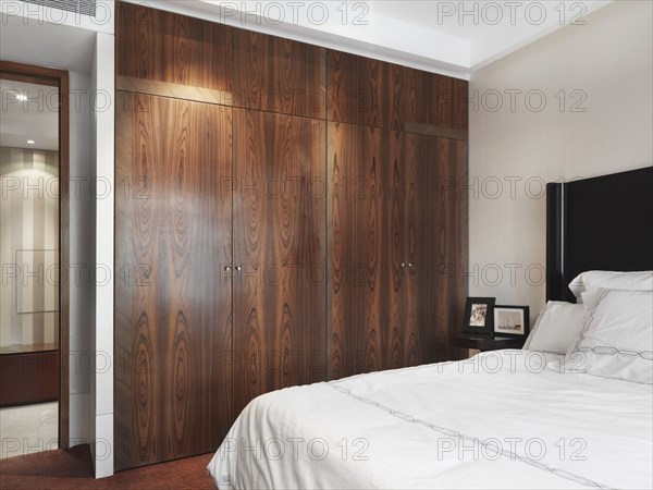 White bed and wooden closet in bedroom