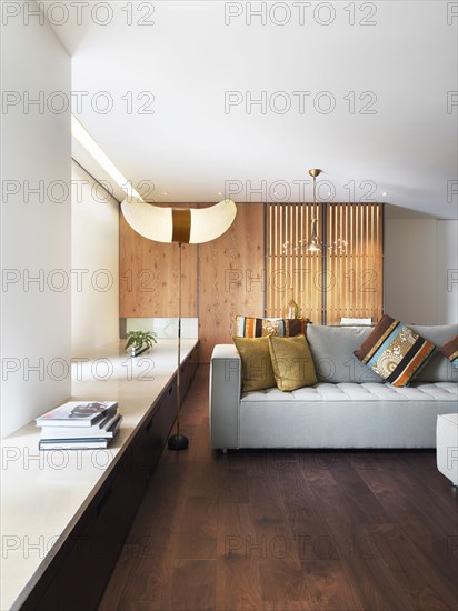 Living room with gray sofa and hardwood floors in modern home