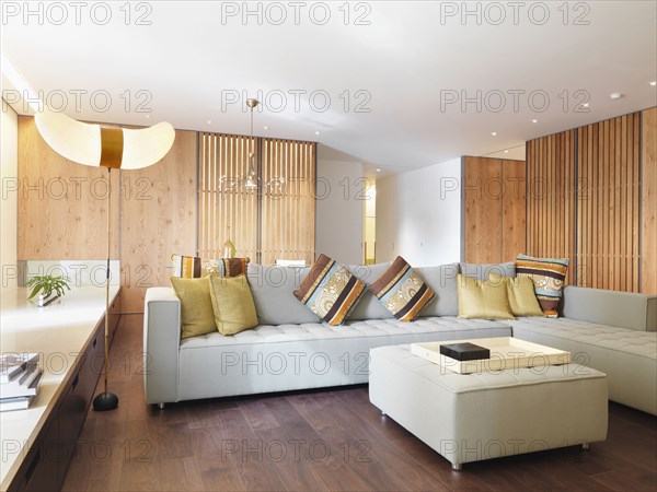 Living room with gray sofa and hardwood floors in modern home