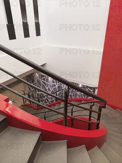 Winding red staircase with handrail