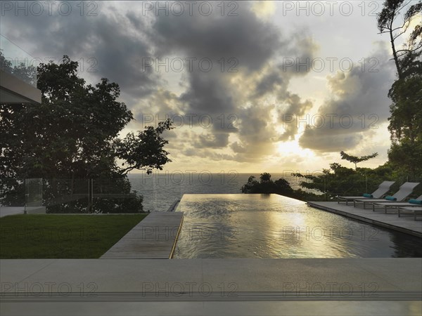 Swimming pool outside of modern home at sunset