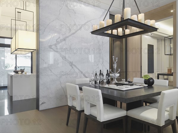 Black and white dining table in dining room with marble wall