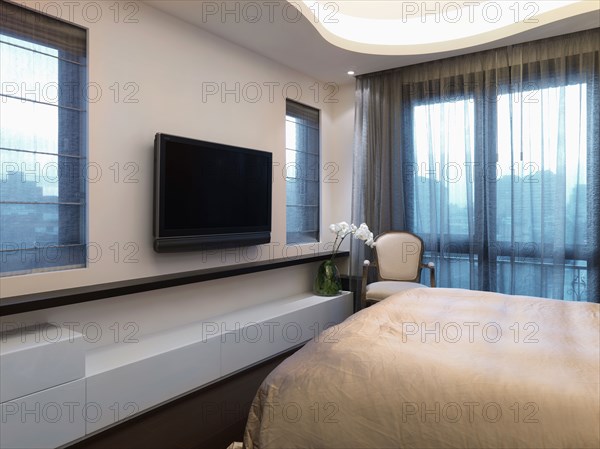 Flatscreen television in modern bedroom