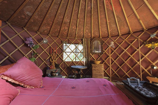 Cropped bed with criss cross designed wall and vaulted ceiling in bedroom at house