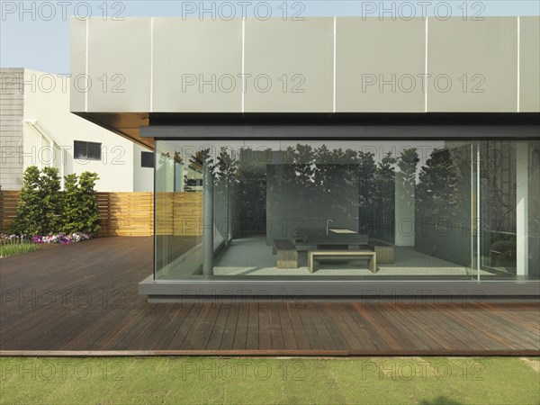 Exterior of modern office building with view of kitchen through glass wall