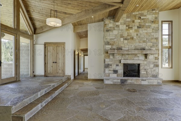 Empty interior with large stone fireplace