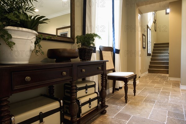 End table and chair in hallway below staircase