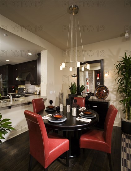 Circular dining table with red leather chairs