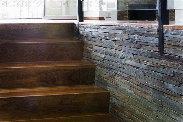 Modern Hardwood  Stairway with Stone Wall