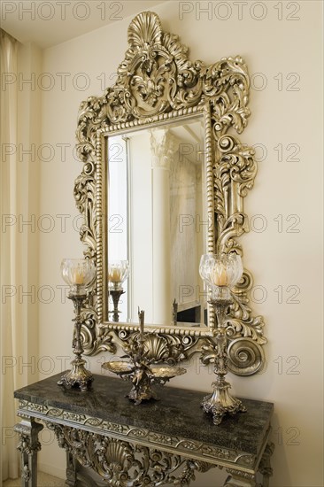 Detail of a decorative mirror above a small side table