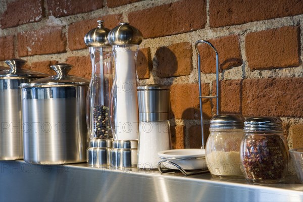 Detail of cooking spices on stainless steel shelf.