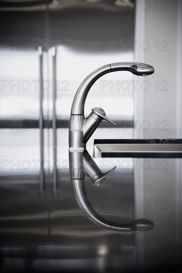 Detail of stainless steel faucet with reflection.