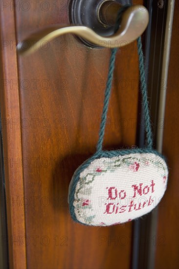 Detail of door handle with do not disturb sign.